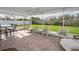 Inviting screened-in patio with brick flooring, ceiling fan, and cozy wicker seating overlooking the yard at 14341 Passage Way, Seminole, FL 33776