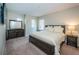 Bedroom featuring a king size bed, dresser with mirror, and two windows with wood blinds at 14806 Harry Colt Ct, Tampa, FL 33626