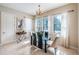 Elegant dining area with a glass table, stylish chairs, and large windows dressed with sheer white curtains at 14806 Harry Colt Ct, Tampa, FL 33626