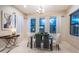 Bright dining room featuring a glass table, modern chandelier, and large windows providing ample natural light at 14806 Harry Colt Ct, Tampa, FL 33626