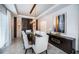 Elegant dining room features a dark wood table with white upholstered chairs and a modern light fixture at 14806 Harry Colt Ct, Tampa, FL 33626