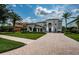 Elegant two-story home showcases manicured landscaping, a paved driveway, and stately columns at 14806 Harry Colt Ct, Tampa, FL 33626