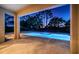 Covered patio area showcasing a beautiful, illuminated in-ground pool and backyard at 14806 Harry Colt Ct, Tampa, FL 33626