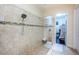 Modern walk-in shower featuring a mosaic tile accent wall and a glass enclosure, next to a walk in closet at 14806 Harry Colt Ct, Tampa, FL 33626