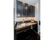 The modern wet bar features dark cabinets, a granite countertop, and stainless steel fixtures for a sleek look at 14806 Harry Colt Ct, Tampa, FL 33626