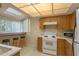 Bright kitchen featuring white appliances, skylight and breakfast bar with stools overlooking backyard at 1500 Sunset Rd # C10, Tarpon Springs, FL 34689