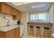 Bright eat-in kitchen featuring white appliances, breakfast bar with stools, sink and coffee maker at 1500 Sunset Rd # C10, Tarpon Springs, FL 34689