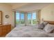 A bedroom with water views from the bay window, hardwood floors, and wicker bedside tables at 1500 Sunset Rd # C10, Tarpon Springs, FL 34689