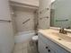 Well-lit bathroom featuring a sink, vanity, toilet, and tiled bathtub at 1510 Mission Hills Blvd # 19-F, Clearwater, FL 33759