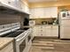 Bright kitchen featuring white cabinets, stainless steel appliances, and laminate flooring at 1510 Mission Hills Blvd # 19-F, Clearwater, FL 33759