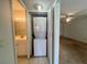 Compact laundry closet equipped with a stacked washer and dryer unit at 1510 Mission Hills Blvd # 19-F, Clearwater, FL 33759