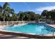 Community swimming pool with palm trees and lounge chairs around it at 1510 Mission Hills Blvd # 19-F, Clearwater, FL 33759