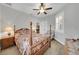 This bedroom features a ceiling fan, a four poster bed and a window with plantation shutters at 1528 Highland Park Dr, Clearwater, FL 33756