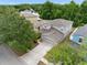 Aerial view of a two-story home featuring a grey exterior, two-car garage, driveway and lush landscaping at 18320 Snowdonia Dr, Land O Lakes, FL 34638