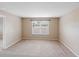 Neutral bedroom with a large window, carpet, and natural lighting, showcasing simplicity and comfort at 18320 Snowdonia Dr, Land O Lakes, FL 34638
