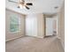 Bright bedroom featuring neutral paint, carpet floors, a ceiling fan, large window and a closet at 18320 Snowdonia Dr, Land O Lakes, FL 34638