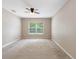 Clean, carpeted bedroom with neutral walls, a ceiling fan, and a large window at 18320 Snowdonia Dr, Land O Lakes, FL 34638