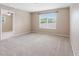 A spacious, neutral-toned bedroom with a large window, carpet, and ample natural light at 18320 Snowdonia Dr, Land O Lakes, FL 34638