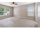 Large, carpeted bedroom with multiple windows, a ceiling fan and neutral walls at 18320 Snowdonia Dr, Land O Lakes, FL 34638