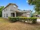 Two-story home featuring a grey exterior, two-car garage, stone accents, covered porch, and manicured landscaping at 18320 Snowdonia Dr, Land O Lakes, FL 34638