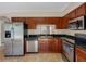 Kitchen showcasing stainless steel appliances, dark wood cabinets, and granite countertops at 18320 Snowdonia Dr, Land O Lakes, FL 34638