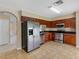 Well-lit kitchen features stainless steel appliances, dark wood cabinetry, and a tile floor at 18320 Snowdonia Dr, Land O Lakes, FL 34638