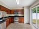 Well-equipped kitchen with stainless steel appliances, dark cabinets, and sliding glass doors to the exterior at 18320 Snowdonia Dr, Land O Lakes, FL 34638