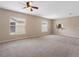 Expansive carpeted living room with abundant natural light and a ceiling fan at 18320 Snowdonia Dr, Land O Lakes, FL 34638