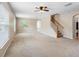 Spacious living room featuring neutral carpet, ceiling fan, and stairs to the upper level at 18320 Snowdonia Dr, Land O Lakes, FL 34638