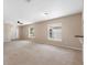 Large, carpeted living room with multiple windows providing natural light at 18320 Snowdonia Dr, Land O Lakes, FL 34638