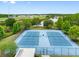 Aerial view of well-maintained community tennis courts, surrounded by lush trees and landscaping at 18320 Snowdonia Dr, Land O Lakes, FL 34638