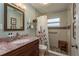 Renovated bathroom featuring a tiled shower with bench and updated vanity at 2048 Douglas Ave, Dunedin, FL 34698