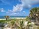 Picturesque beach scene with clear turquoise water, white sand, and lush tropical vegetation at 2048 Douglas Ave, Dunedin, FL 34698