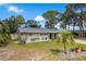 Charming single-story home with stone accents, a well-manicured lawn, and mature trees at 2048 Douglas Ave, Dunedin, FL 34698