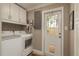 Convenient laundry room with modern washer/dryer and outside access, plus storage at 2048 Douglas Ave, Dunedin, FL 34698