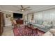 The light-filled living room has tile floors, a large flat-screen TV, and plush seating under a modern ceiling fan at 2048 Douglas Ave, Dunedin, FL 34698