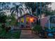 A charming outdoor -shed with decorative stained-glass window, adjacent to a wooden walkway and lush landscaping at 2048 Douglas Ave, Dunedin, FL 34698