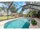 The enclosed in-ground pool overlooks the serene backyard with a charming shed at 2048 Douglas Ave, Dunedin, FL 34698
