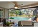 The enclosed in-ground pool boasts an extended patio and landscaping at 2048 Douglas Ave, Dunedin, FL 34698