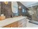 Stylish bathroom showcasing dark tile, a modern vanity with gold fixtures, and glass shower at 2084 Massachusetts Ne Ave, St Petersburg, FL 33703