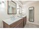 Bright bathroom with double vanity, modern fixtures, wood cabinets, and neutral tiling at 2084 Massachusetts Ne Ave, St Petersburg, FL 33703