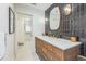 Sleek bathroom with wood vanity, unique tile, and a doorway to the walk-in closet at 2084 Massachusetts Ne Ave, St Petersburg, FL 33703