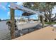 Boat on a lift and dock on a sunny day with lush landscaping and neighborhood homes in the background at 2084 Massachusetts Ne Ave, St Petersburg, FL 33703
