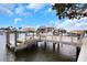 Dock with a boat lift, seating area and walkway on a sunny day overlooking the water and neighborhood at 2084 Massachusetts Ne Ave, St Petersburg, FL 33703
