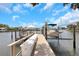 Dock with a boat lift, dock box and walkway overlooking the water with homes in the background on a sunny day at 2084 Massachusetts Ne Ave, St Petersburg, FL 33703