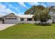 Inviting single-story home with a well-manicured lawn, lush trees, and a two-car garage at 2084 Massachusetts Ne Ave, St Petersburg, FL 33703