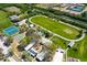 Aerial view of community recreational facilities, including tennis courts, basketball courts, a track, and green spaces at 214 Lookout Dr, Apollo Beach, FL 33572