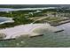 An aerial shot of a white sand beach with a small parking lot, breakwater, and inlet at 214 Lookout Dr, Apollo Beach, FL 33572