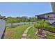 Landscaped backyard featuring a stepping stone path, lush green grass, and manicured plantings at 214 Lookout Dr, Apollo Beach, FL 33572