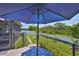 This home's lush backyard features a picnic table with umbrella, leading to an enclosed lanai for peaceful outdoor living at 214 Lookout Dr, Apollo Beach, FL 33572